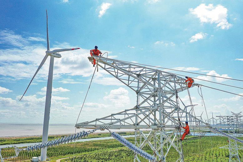 施工人員架設(shè)國家電投中電智慧海上風力發(fā)電廠上網(wǎng)線路